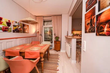 Ein gemütlicher Essbereich mit einem Holztisch und bequemen Stühlen. Hier haben bis zu 6 Personen Platz. Blick in die Küche und auf die Terrasse.