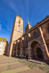 Eine beeindruckende Kirche mit zwei Türmen steht vor einem klaren blauen Himmel. Der Platz in der Nähe ist ruhig und einladend.