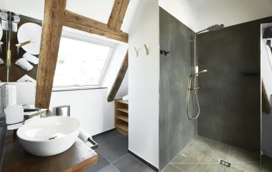 Ein modernes Badezimmer mit einer offenen Dusche und stilvollen Holzdetails. Die Einrichtung ist hell und einladend.