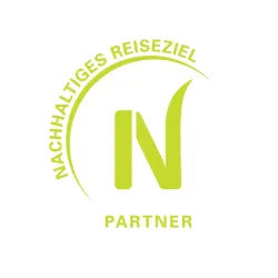 Ein Logo mit dem Text "Nachhaltiges Reiseziel" und dem Wort "Partner". Die Farben sind hellgrün und weiß.