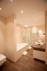 Ein modernes Badezimmer mit einer Badewanne und separierter Dusche. Die Wände sind hell, und der Boden ist aus Holz.