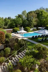 Ein schöner Garten mit einem Swimmingpool und bequemen Liegen. Umgeben von Bäumen und grünen Pflanzen bietet der Ort eine entspannte Atmosphäre.