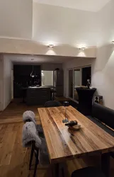 Ein modern eingerichteter Essbereich mit einem Holztisch und stilvollen Stühlen. Die sanfte Beleuchtung schafft eine gemütliche Atmosphäre.