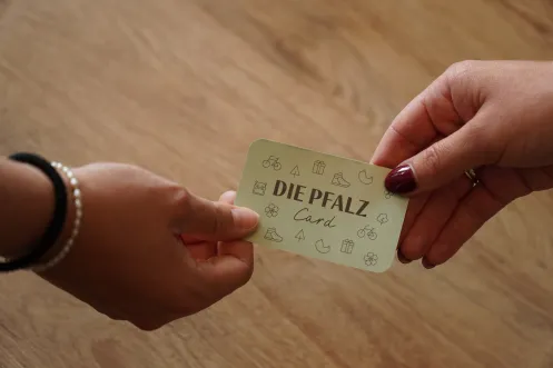 DIe Pfalzcard wird an einer Theke übergeben