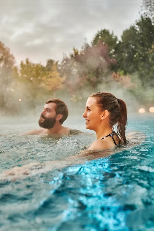 In wohlig warmen Wasser bei frischer Luft entspannen zwei Personen