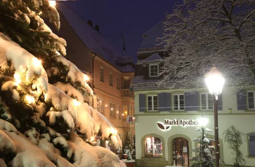 Verschneiter Marktplatz mit abendlicher Beleuchtung