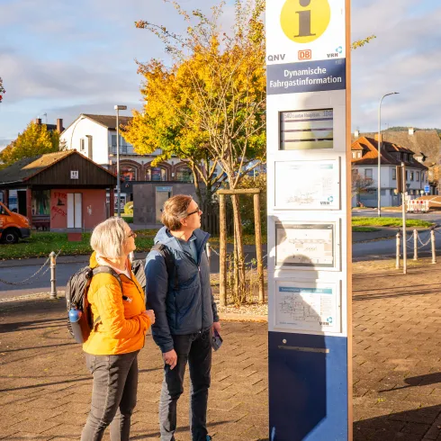 Ein Pärchen schaut auf die Fahrplaninformation
