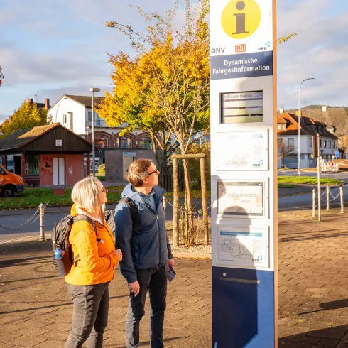 Ein Pärchen schaut auf die Fahrplaninformation